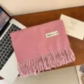 Dettaglio di una morbida sciarpa rosa tipo cashmere con frange ed etichetta sobria - 200cm (Include Nappine) / Rosa coreano