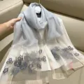 Detailed macro view of silver silk blend scarf with elegant grey floral embroidery - 180cm / Grey Blue