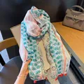 Detailed view of lightweight Bohemian floral print shawl featuring delicate red tassels - Pink and Green Paisley