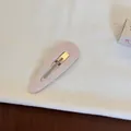 Gros plan d'une barrette BB en tissu rose sur un fond de tissu blanc minimaliste. - Style Goutte d'Eau Ajouré / Rose