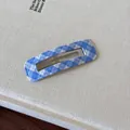 Primo piano di un fermaglio per capelli in tessuto a quadretti azzurro su fondo bianco - A quadri / Quadrato Blu Scuro