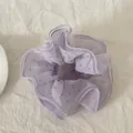 Λεπτομερής άποψη από μωβ λουλουδάτο scrunchie με κομψά βολάν σε λευκό λινό ύφασμα - Στυλ Λεπτής Μέσης