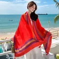 Detailed view of the vibrant red ethnic pattern sun protection shawl against a beach background - No.23
