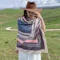 Detail view of a woman wearing an ethnic pattern shawl with tassels in a grassland - Variant 231