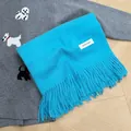 Soft bright blue winter scarf for women featuring fringe tassels and a minimalist white label - Lake Blue