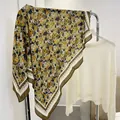 Detailed view of a yellow floral cotton linen scarf hanging on a rack with a sweater - Yellow Floral / 90*90cm
