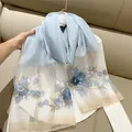 Detail view of light blue silk blend scarf with elegant floral embroidery - 180cm / Aqua