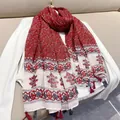 Detailed macro view of vintage ethnic red floral scarf featuring blue and red tassels - Wine Red Small Floral / 180cm