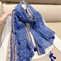 Close-up detail of lightweight cotton linen scarf with blue floral pattern and tassels. - Blue Floral / 180cm