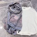 Detailed macro view showing ethnic paisley print and fringe tassels on a soft linen scarf - Pink Blue Floral / 180cm