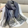 Detail of elegant semi-transparent faux silk scarf with gold glitter and pearl trim - 180cm / Dark Gray