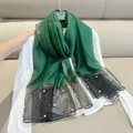 Close-up of green faux silk scarf with pearl embellishments and black mesh trim - 180cm / Emerald