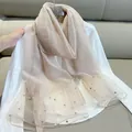 Elegant champagne silk scarf with pearl embellishments draped over a white shirt - 180cm / Flesh Pink