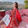 Elegant bohemian ethnic shawl shown worn by model in a scenic travel setting - 180x90cm / Large Red Exotic Geometric (127)