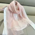 Elegant detail of a pink faux silk scarf with decorative pearls and a sheer glittery border - 180cm / Pink