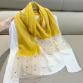 Detail showing yellow imitation silk scarf with pearl embellishments and sheer trim - 180cm / Yellow