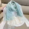 Close-up detail of light blue scarf featuring white pearls and golden glitter hem - 180cm / Fresh Blue