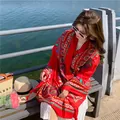 Close-up of a vibrant red ethnic pattern beach shawl worn by woman at seaside resort - 180x90cm / Red Print