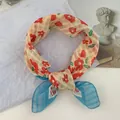 Vue détaillée d'un foulard en soie à fleurs rouges et extrémités à rayures bleues - 58*58cm / Rouge Intense Petite Fleur