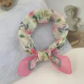 Close-up of a pink floral silk scarf styled as a neckerchief on a white background. - 58*58cm / Rose Pink