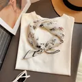 Primer plano de un pañuelo de seda estilo francés con estampado de caballos en camiseta. - Pony Beige