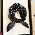 Detailed view of black and white silk neck scarf with paisley and polka dot pattern - 70cm / Black Polka Dot Paisley