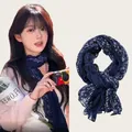 Elegant navy blue long silk scarf with a white floral pattern worn by a model - 180cm / Dark Blue Floral