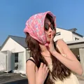 Close-up detail of a thin pink floral cotton-linen headscarf worn by a model outdoors - 58x58cm / Pink Large Flower