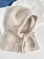 Nahaufnahme eines beigen Woll-Balaclava-Schals mit Knopf- und Schleifendetail - Einheitsgröße / Beige