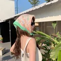 Asian model wearing an orange floral cotton linen headscarf in an outdoor setting - Green Orange Small Flower