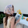 Model wearing a pink floral cotton-linen headscarf in an outdoor cafe setting - Pink Blue Small Flower