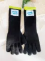 Primer plano de guantes largos de punto negros con puños verde neón y etiquetas - Talla única / Negro