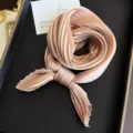 Elegant pleated silk neckerchief in champagne pink displayed on a luxury black tray - Ivory / 45-90cm