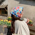 Floral cotton linen square scarf headscarf styled on model in an outdoor garden setting - Lush Large Flower