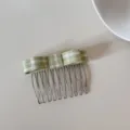 High-angle detailed shot of a green and white plaid bow on a silver metal hair comb - Green Gingham Bow Style (FJ83135)
