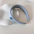 Detail van een gevoerde blauwe haarband met stippen en schattige knoop- en hartdetails. - Knoop Hoofdband / Blauwe Stippen