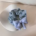 Detailweergave van een blauwe haarelastiek met stippen en een grote stoffen strik - Strik Haarelastiek / Blauwe Stippen