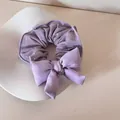 Detailansicht eines lila gepunkteten Haargummis mit einer weichen Schwammschleife - Schleife Haargummi / Lila Polka Dots