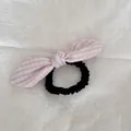 Detalle que muestra el lazo de rayas rosas y la textura elástica negra del coletero - Lazo de Cuadros Rosa