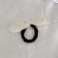 Primer plano de un coletero negro con lazo de rayas crema sobre fondo lino - Coletero a Cuadros Amarillo