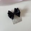 Close-up detail of a elegant black satin bow hair comb for bangs and hair styling. - Black Bow Comb