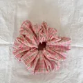 Détail d'un chouchou à carreaux roses montrant la texture douce du tissu - Style de Nuage / Gros Carreaux Roses
