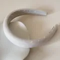 Vue détaillée d'un serre-tête en satin crème avec de délicats motifs de cœurs et de nœuds blancs - 3CM de large / Beige Imprimé Animal