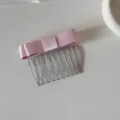 Close-up of pink satin ribbon bow hair comb with silver metal teeth for ballet style - Bow Hair Comb / Pink