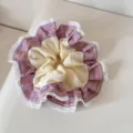 Close-up detail of a purple plaid and cream scrunchie with white lace trim and ruffles - Scrunchie / Purple Plaid