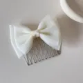 Detailed macro view of a sweet white mesh bow hair comb for girls featuring silver metal tines - Mesh Bow - Comb / Beige
