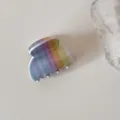 Vue détaillée d'une pince à cheveux en acrylique aux rayures arc-en-ciel sur fond beige neutre - S / Arc-en-ciel