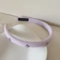 Primer plano de una diadema de esponja lavanda con elegantes lazos de cristal. - 1,5 cm de ancho / Púrpura