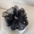 Detailed view of an elegant black mesh scrunchie decorated with white faux pearls - Scrunchie / Black
