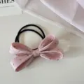 Gros plan détaillé d'un chouchou à nœud en tissu rose à pois sur une surface blanche - Rose